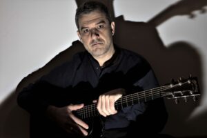 Muzyk w czarnej koszuli w gitarą w ręce